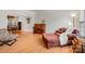 Cozy living room features a plush sofa, accent chair, piano, and wood floors, perfect for relaxation and entertainment at 2620 Shady Reach Ln, Charlotte, NC 28214