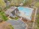 Aerial view of a community pool and clubhouse, surrounded by trees and landscaping, with parking at 2620 Shady Reach Ln, Charlotte, NC 28214