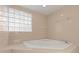 This tiled bathroom features a unique glass block window and a corner soaking tub for relaxation at 273 Leeward Point Loop # 14, Taylorsville, NC 28681