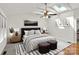 A bright bedroom with a ceiling fan, skylight, and natural light, showcasing a comfortable and modern aesthetic at 273 Leeward Point Loop # 14, Taylorsville, NC 28681