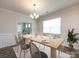 Formal dining room with elegant chandelier lighting, a large table setting, and a view into another room at 3199 Windhaven Ln, Tega Cay, SC 29708