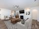 Bright, open living room with a fireplace, built-in shelving, and a ceiling fan at 3199 Windhaven Ln, Tega Cay, SC 29708