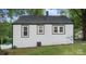 Rear exterior view of charming white home featuring brick detail around the windows, roof, and lawn at 331 5Th Se Ave, Hickory, NC 28602