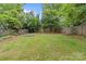 Lush backyard featuring a garden, green grass, a wooden fence, and mature trees, offering a serene outdoor space at 3320 Eastwood Dr, Charlotte, NC 28205