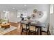 Dining area open to the kitchen and living room, featuring a modern table, decor, and hardwood floors at 3320 Eastwood Dr, Charlotte, NC 28205