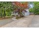 A beautiful home featuring a side driveway and elegant landscaping, including a striking red tree on the right at 3320 Eastwood Dr, Charlotte, NC 28205