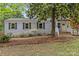 Charming home featuring a brick exterior, a welcoming front porch, and a mature shade tree at 3320 Eastwood Dr, Charlotte, NC 28205