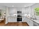 Updated kitchen featuring granite countertops, white cabinets, stainless steel appliances, and hardwood flooring at 3320 Eastwood Dr, Charlotte, NC 28205