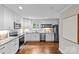 Well-lit kitchen with white cabinets, granite countertops, stainless steel appliances, and dark hardwood flooring at 3320 Eastwood Dr, Charlotte, NC 28205