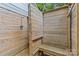 Rustic outdoor shower with wood paneling, bench, and shower fixtures, perfect for rinsing off after outdoor activities at 3320 Eastwood Dr, Charlotte, NC 28205