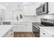 Bright, modern kitchen features white cabinets, stainless steel appliances, and a farmhouse sink at 404 S Greenbriar Rd, Statesville, NC 28625
