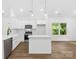 Modern kitchen with white cabinetry, stainless steel appliances, island, and wood flooring at 404 S Greenbriar Rd, Statesville, NC 28625