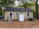 Backyard featuring a one-story house with a dark roof, tan siding, and small white door at 4100 Howie Cir, Charlotte, NC 28205