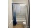 Bathroom features a tub/shower with tiled surround, toilet, and blue shower curtain at 4100 Howie Cir, Charlotte, NC 28205