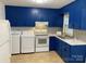 Bright kitchen showcasing blue cabinets, modern white appliances including a range, and tile flooring at 4100 Howie Cir, Charlotte, NC 28205
