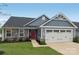 Charming single-Gathering home with gray siding, stone accents, attached garage, and manicured lawn at 4205 Jones Creek Ln, Charlotte, NC 28215