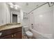 Bright bathroom with granite countertop, a dark wood vanity, and tub with shower at 444 Snapdragon Dr, Clover, SC 29710