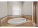 Bright bathroom displaying a soaking tub with tile surround and a window view at 444 Snapdragon Dr, Clover, SC 29710
