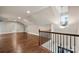 Expansive bonus room with hardwood floors, natural light, and wrought iron staircase at 444 Snapdragon Dr, Clover, SC 29710