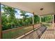 View from covered wood deck overlooking a scenic backyard with a lush tree canopy at 444 Snapdragon Dr, Clover, SC 29710