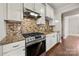 Modern kitchen with stone backsplash, stainless steel appliances, and a gas range at 444 Snapdragon Dr, Clover, SC 29710