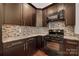 Modern kitchen featuring dark wood cabinets, granite countertops and stainless steel appliances at 444 Snapdragon Dr, Clover, SC 29710