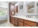 Bathroom vanity with double sinks, wooden cabinets, white countertops, decorative mirrors, and view of tiled shower at 4902 Looking Glass Trl, Denver, NC 28037