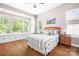 Serene bedroom with a window seat, hardwood floors, and a comfortable bed with side tables and lamps at 4902 Looking Glass Trl, Denver, NC 28037