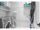 A modern laundry room with front loading washer and dryer, overhead storage, and cleaning supplies at 4902 Looking Glass Trl, Denver, NC 28037