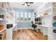 A bright office space features built-in shelving and a workstation with a view of the neighborhood through the windows at 4902 Looking Glass Trl, Denver, NC 28037