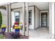 Inviting covered porch features chairs and blue flower pots with yellow flowers at 4902 Looking Glass Trl, Denver, NC 28037