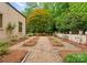 Landscaped backyard featuring manicured garden beds and gravel walkways bordered by mature trees at 5030 Hardison Rd, Charlotte, NC 28226