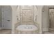 Elegant bathroom with a marble-framed soaking tub and a seamless glass shower at 5030 Hardison Rd, Charlotte, NC 28226