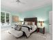 Bright bedroom with a modern aesthetic featuring wood accents, neutral bedding, and ambient lighting at 5030 Hardison Rd, Charlotte, NC 28226