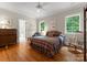 Inviting bedroom with hardwood floors, two windows, plaid bedding, and neutral-toned walls at 5030 Hardison Rd, Charlotte, NC 28226