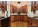 Elegant butler pantry with custom cabinetry, arched design, hardwood floors, and granite countertops at 5030 Hardison Rd, Charlotte, NC 28226