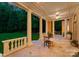 Covered patio featuring elegant columns, stone flooring, and a cozy outdoor dining area at 5030 Hardison Rd, Charlotte, NC 28226