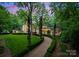 Beautiful property with well-kept lawn and winding path surrounded by lush landscaping at 5030 Hardison Rd, Charlotte, NC 28226