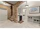 Charming kitchenette with brick archway, white cabinetry, and black appliances adjacent to stairs at 5030 Hardison Rd, Charlotte, NC 28226