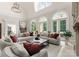 Grand living room with high ceilings, arched windows, plush seating, and elegant chandelier at 5030 Hardison Rd, Charlotte, NC 28226