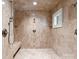 Tiled walk-in shower with bench seating, multiple shower heads, and a window for natural light at 5030 Hardison Rd, Charlotte, NC 28226