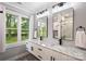 This bathroom features a double sink vanity with marble countertops, modern fixtures, and a large window at 616 Trailing Rock Dr, Charlotte, NC 28214