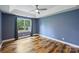 This bedroom features a tray ceiling, ceiling fan, hardwood floors, and a window for plenty of natural light at 616 Trailing Rock Dr, Charlotte, NC 28214