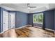 Spacious blue bedroom features hardwood floors, tray ceiling, large window, and private bath at 616 Trailing Rock Dr, Charlotte, NC 28214