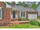 Close-up of the front of the brick home featuring fresh landscaping and a two car garage at 616 Trailing Rock Dr, Charlotte, NC 28214