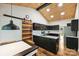 A modern kitchen with dark cabinets, granite countertops, and a unique wood ceiling with recessed lighting at 616 Trailing Rock Dr, Charlotte, NC 28214