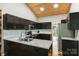 Bright kitchen with granite countertops, stainless steel appliances, dark cabinets, and wood plank ceiling at 616 Trailing Rock Dr, Charlotte, NC 28214