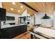 Open-concept kitchen with granite counters, black cabinets, stainless appliances, wood ceiling, and a connecting living space at 616 Trailing Rock Dr, Charlotte, NC 28214