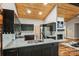 Modern kitchen featuring granite countertops, stainless appliances, wood ceiling, and a view to the living area at 616 Trailing Rock Dr, Charlotte, NC 28214