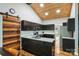 A modern kitchen featuring granite countertops, black cabinets, stainless appliances, and a striking wooden ceiling at 616 Trailing Rock Dr, Charlotte, NC 28214